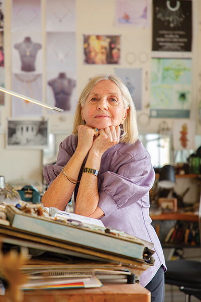 Dorothy Erickson poses for a portrait in her studio, whilst leaning on a drawing table