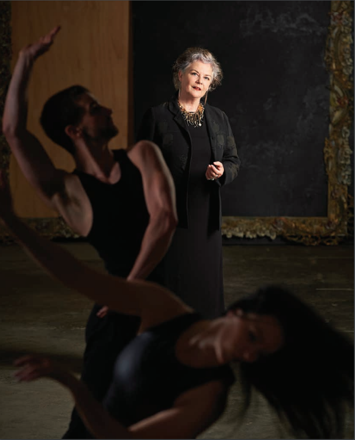 Chrissie Parrott standing with two dancers performing in the foreground