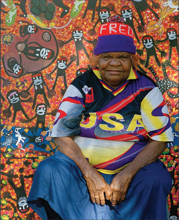 Mary McLean sitting in front of one of her paintings