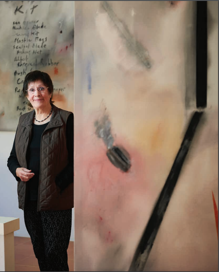 Miriam Stannage standing next to one of her paintings