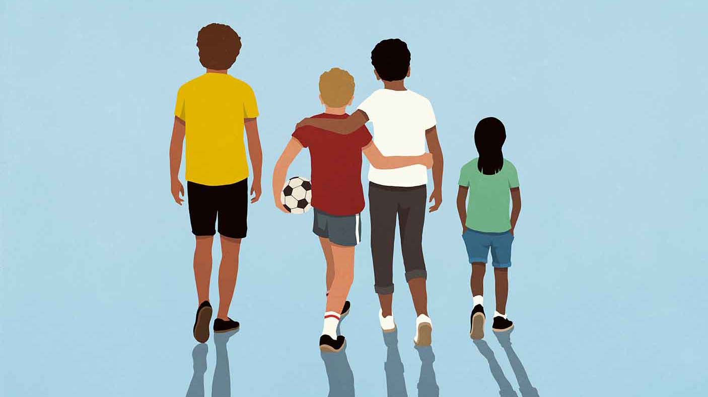 A group of kids, one holding a soccer ball, facing away