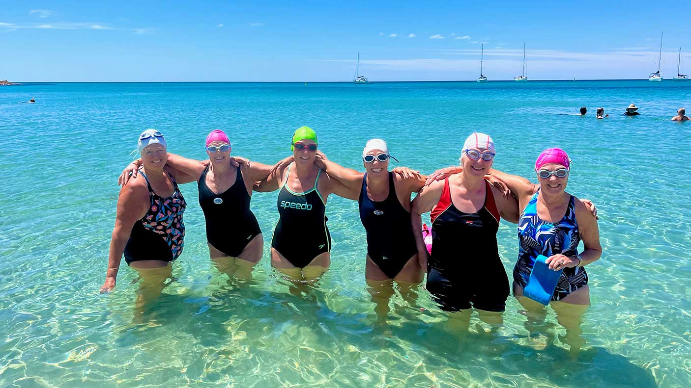 A group of swimmers standing together in shallow water