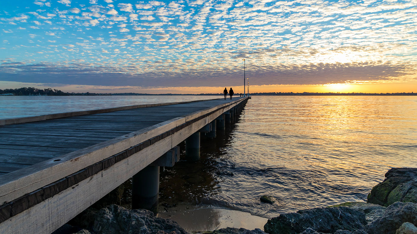 Pier over ocean against the sky during sunset - stock photo