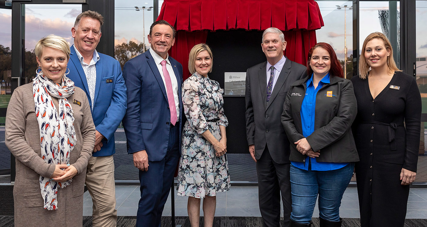 A group of people standing in front of a plaque.