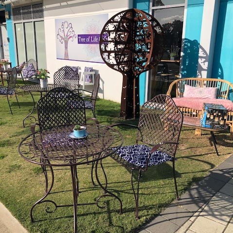 An alfresco area with tables and chairs on a lawn