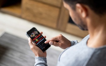 An image of a man on his phone using a betting app