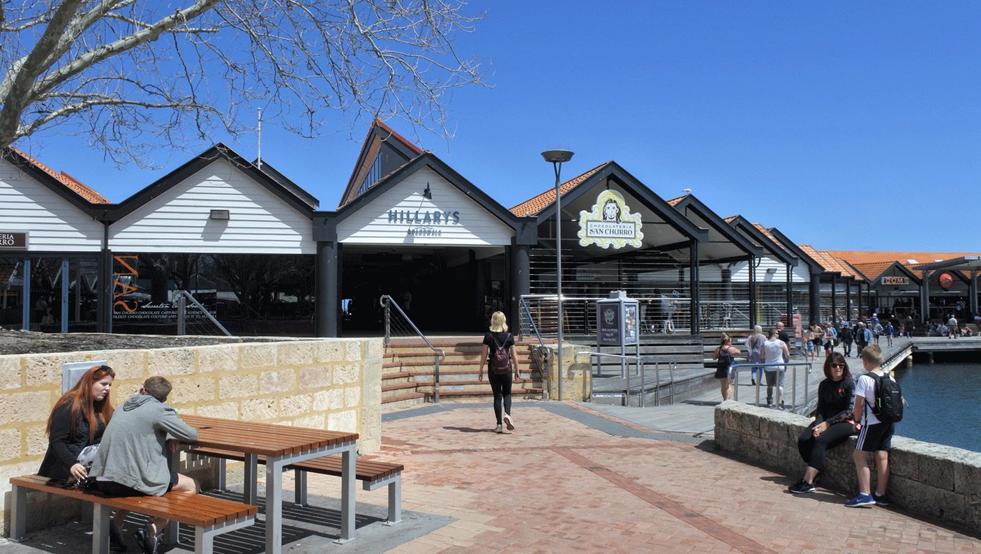 The board walk at Hillarys boat harbour, with people walking and sitting on outdoor furniture