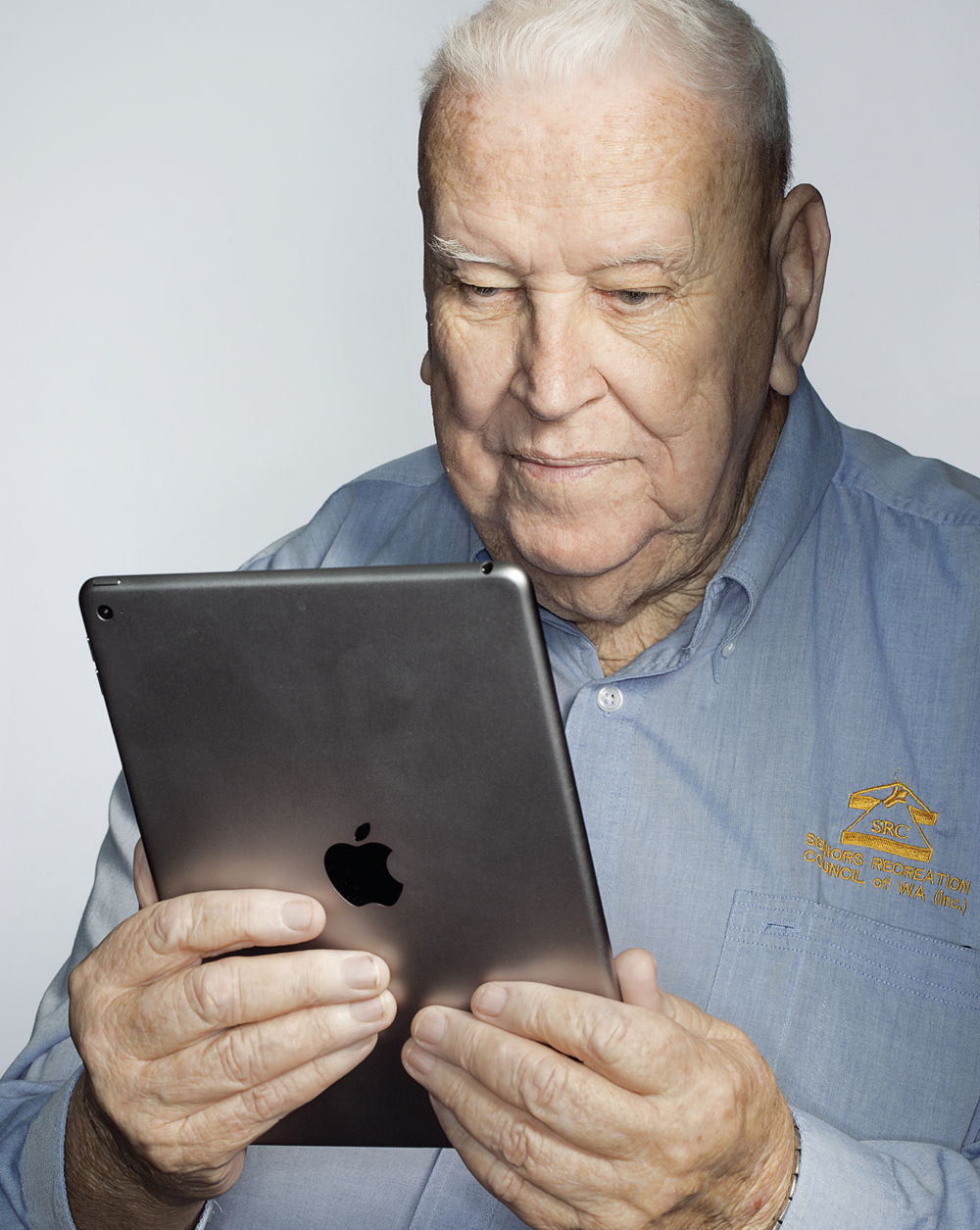 Portrait of Hugh Rogers looking at a tablet
