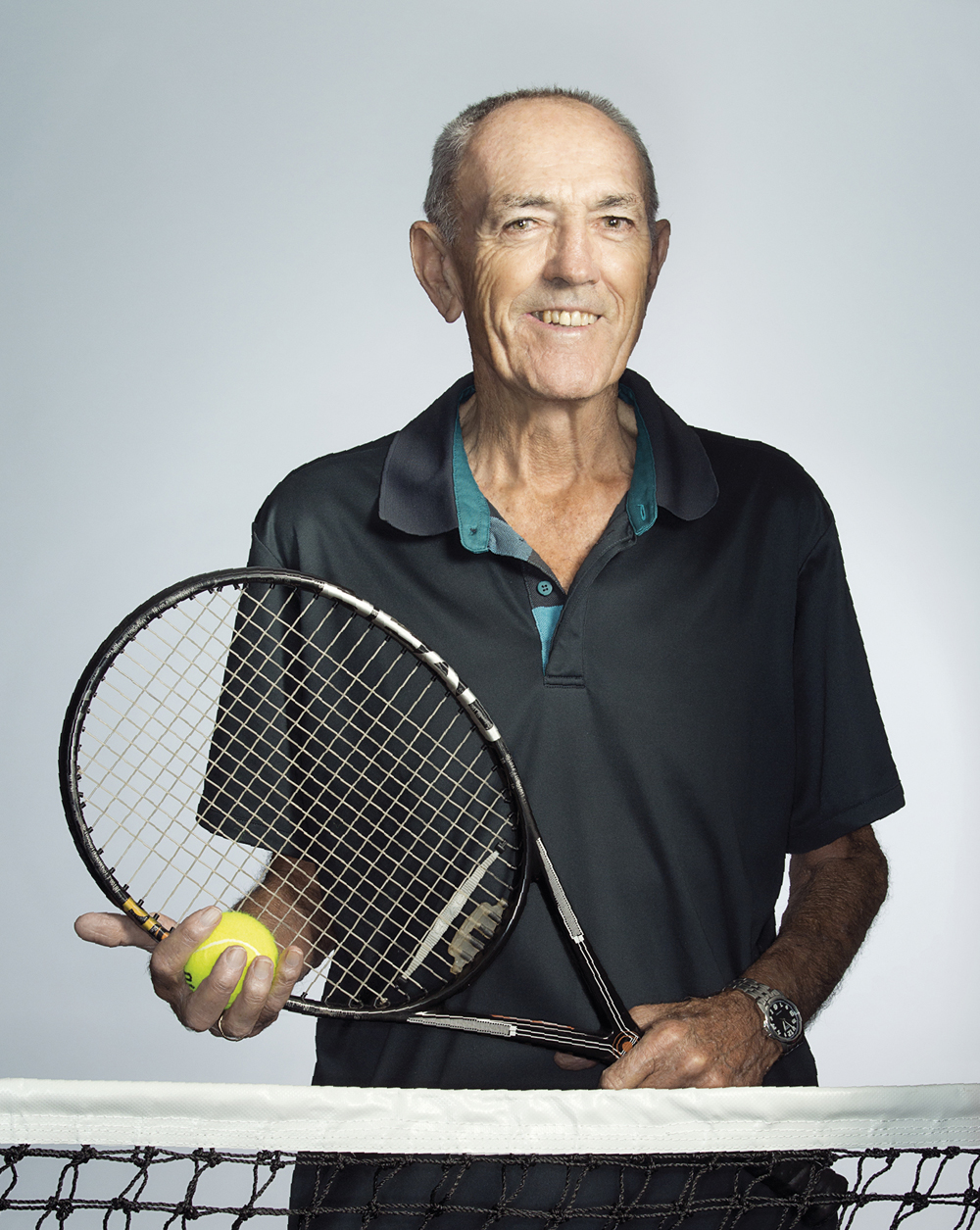 Portrait of Michael Harris holding a tennis requet and ball